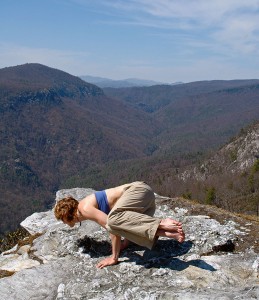 Yoga on a rock with a mountain view.